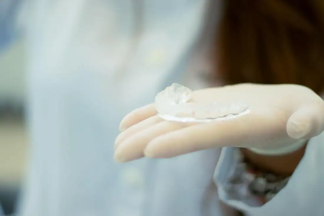 Dental professional holding a transparent night guard