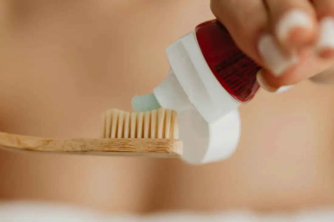putting toothpaste on a toothbrush