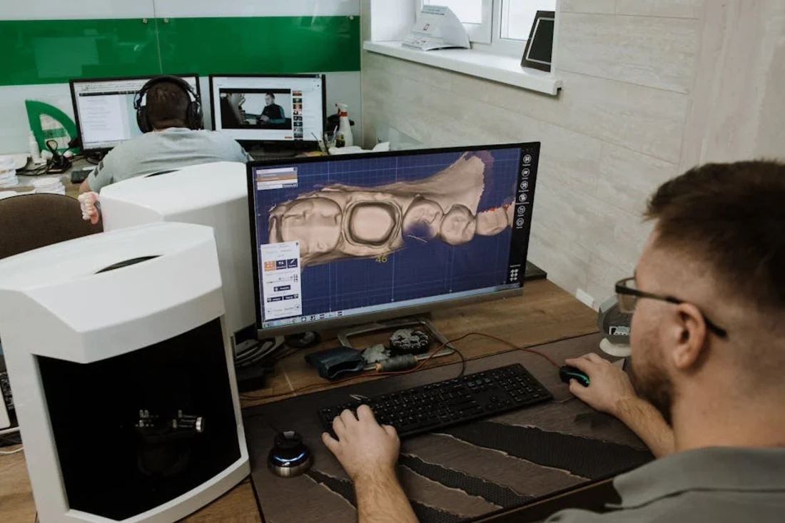 Dental technician using CAD software.