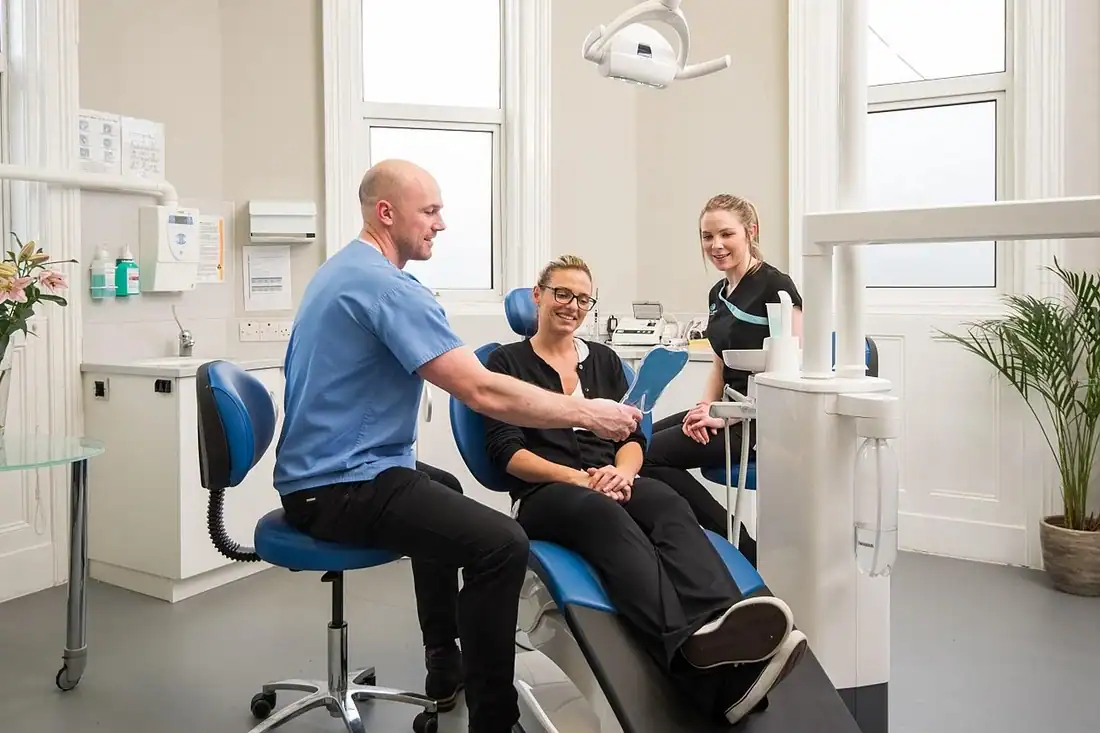 patient. dentist, and dental assistant in clinic