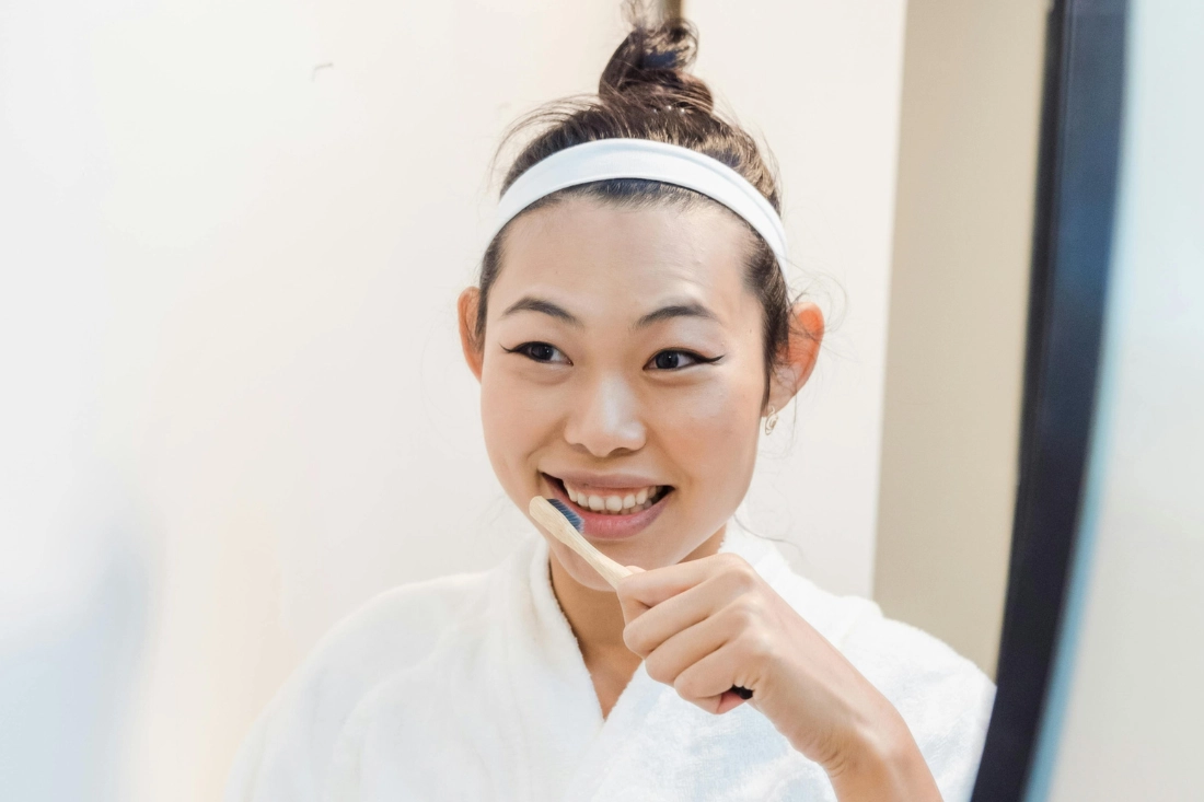 woman brushing her teeth to maintain oral health or dental health