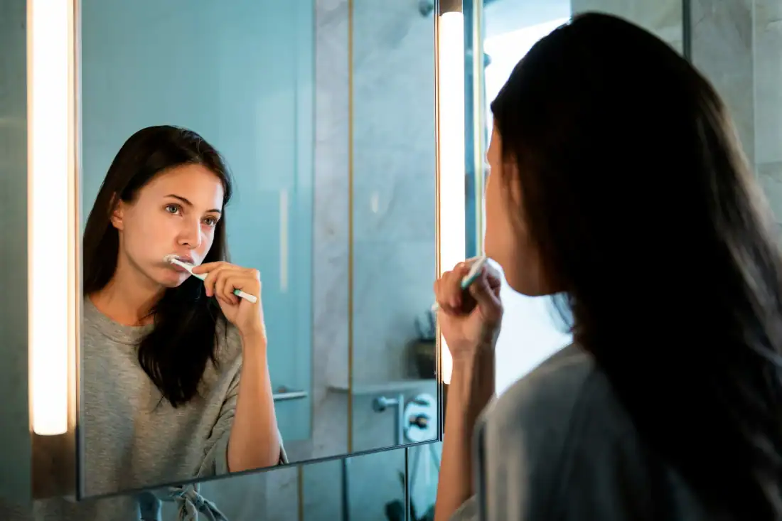 Woman brushing her teeth in the morning