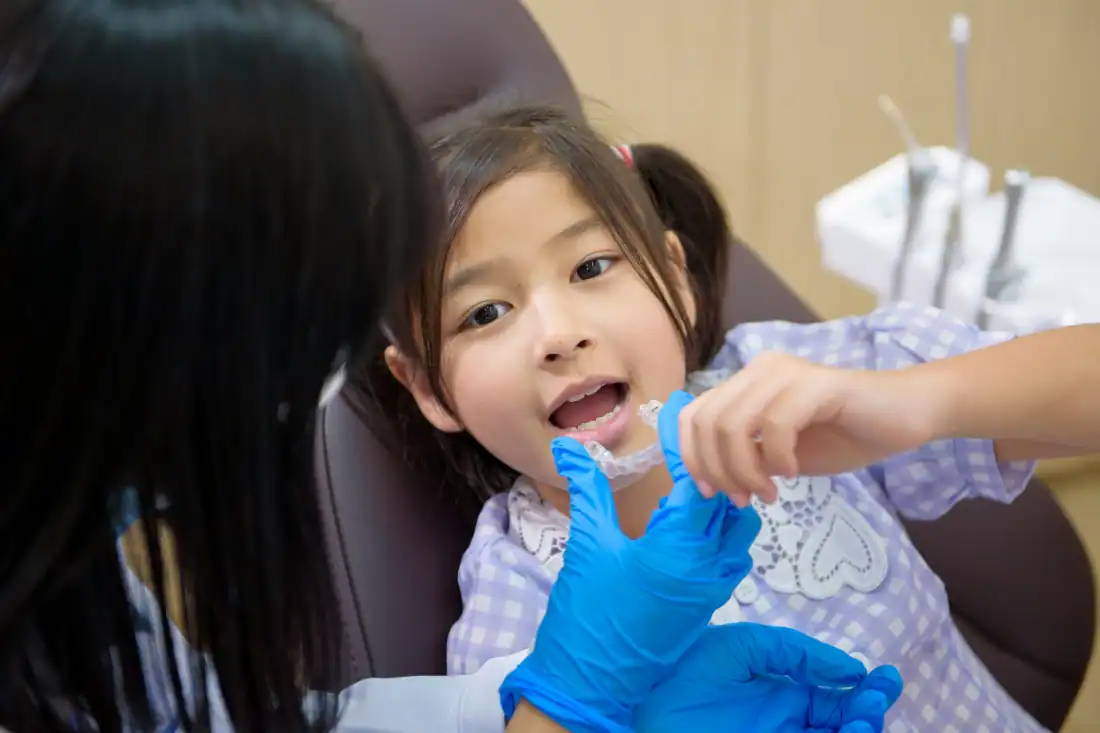 girl holding a cleat set of aligner