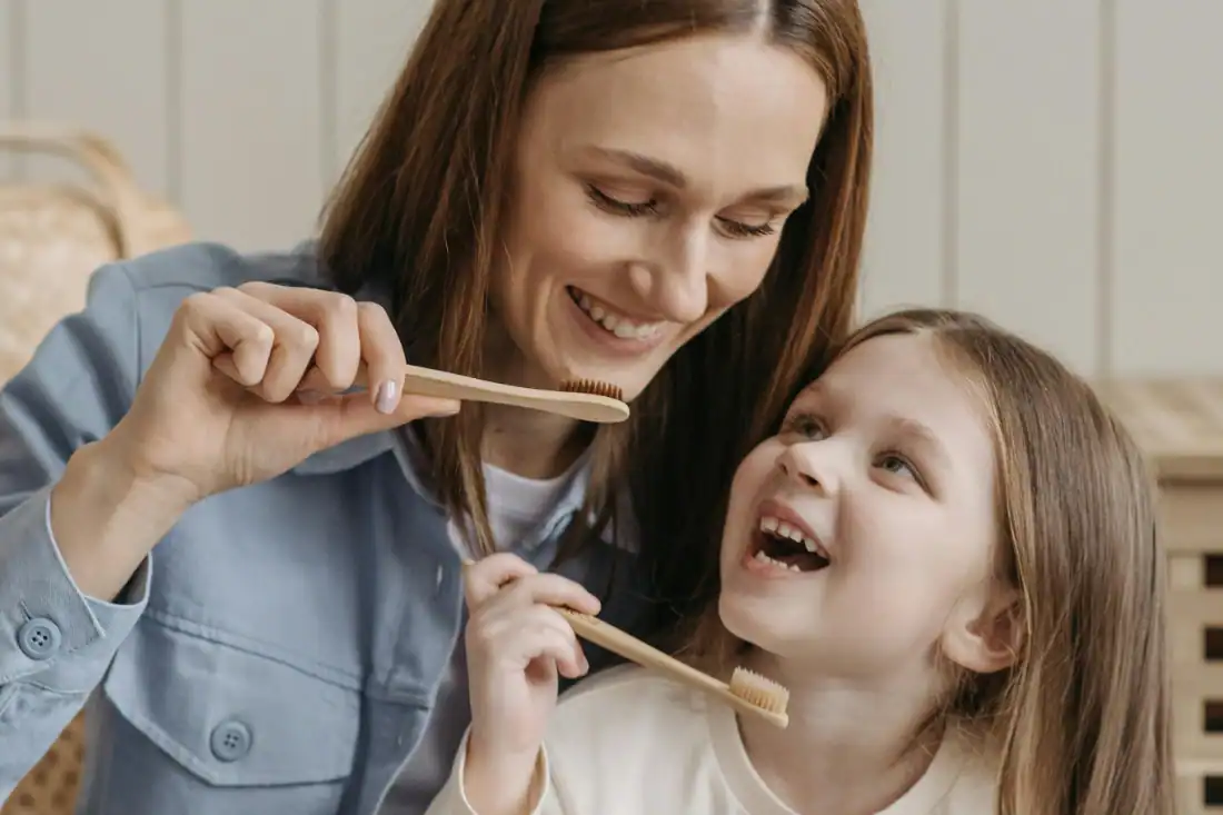 mother and daughter brushing their teeth