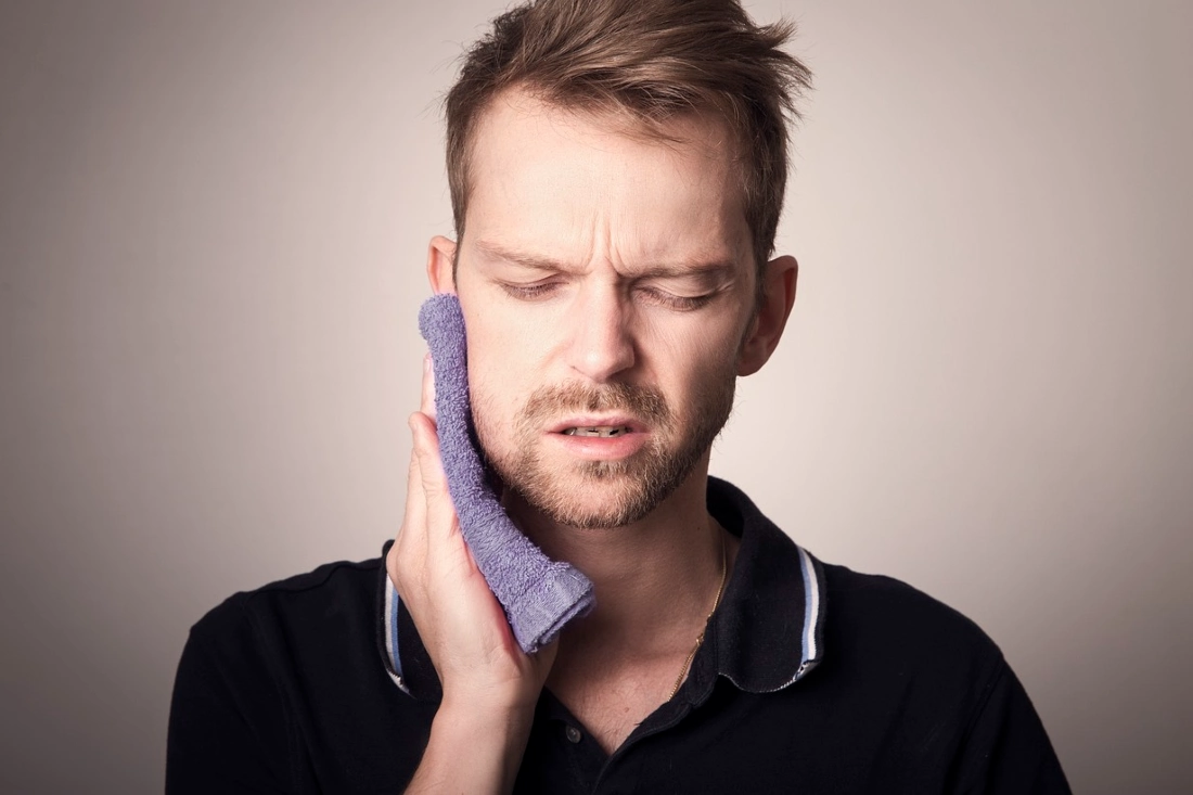 man experiencing pain due to swollen gums