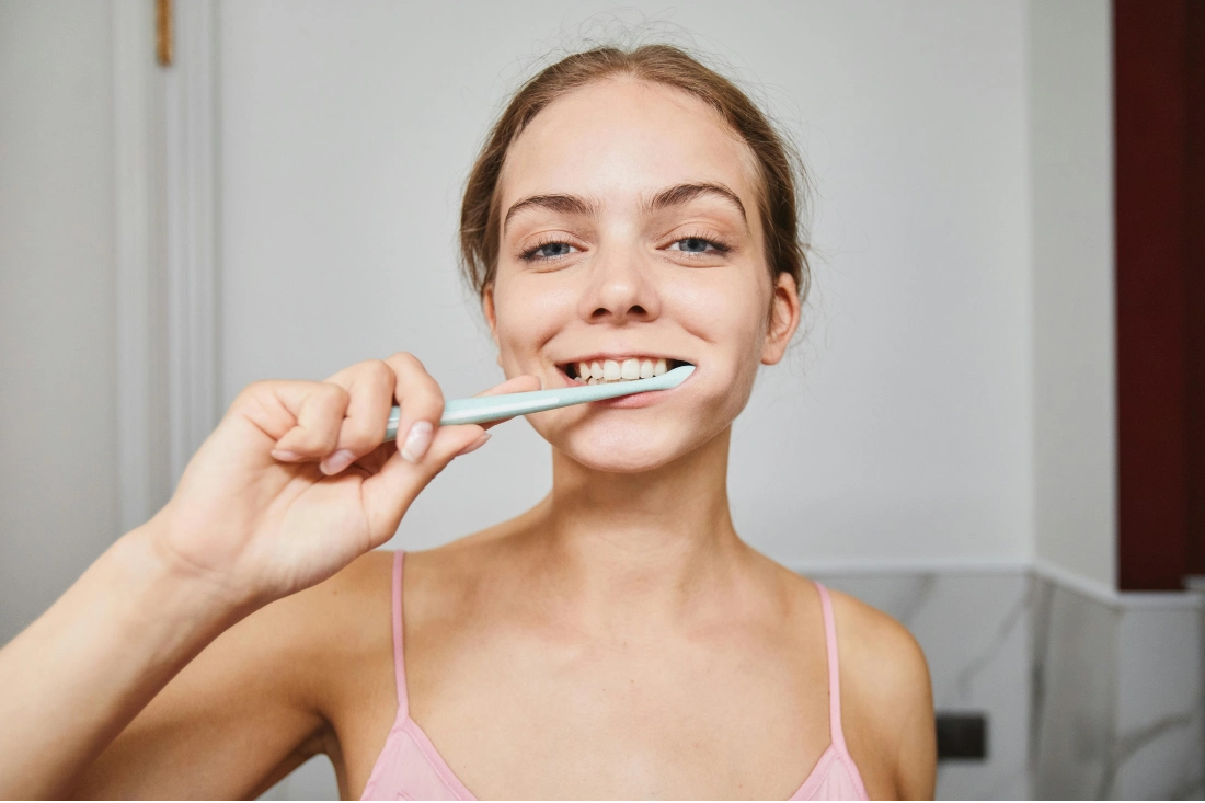 a woman brushing her teeth in the bathroom