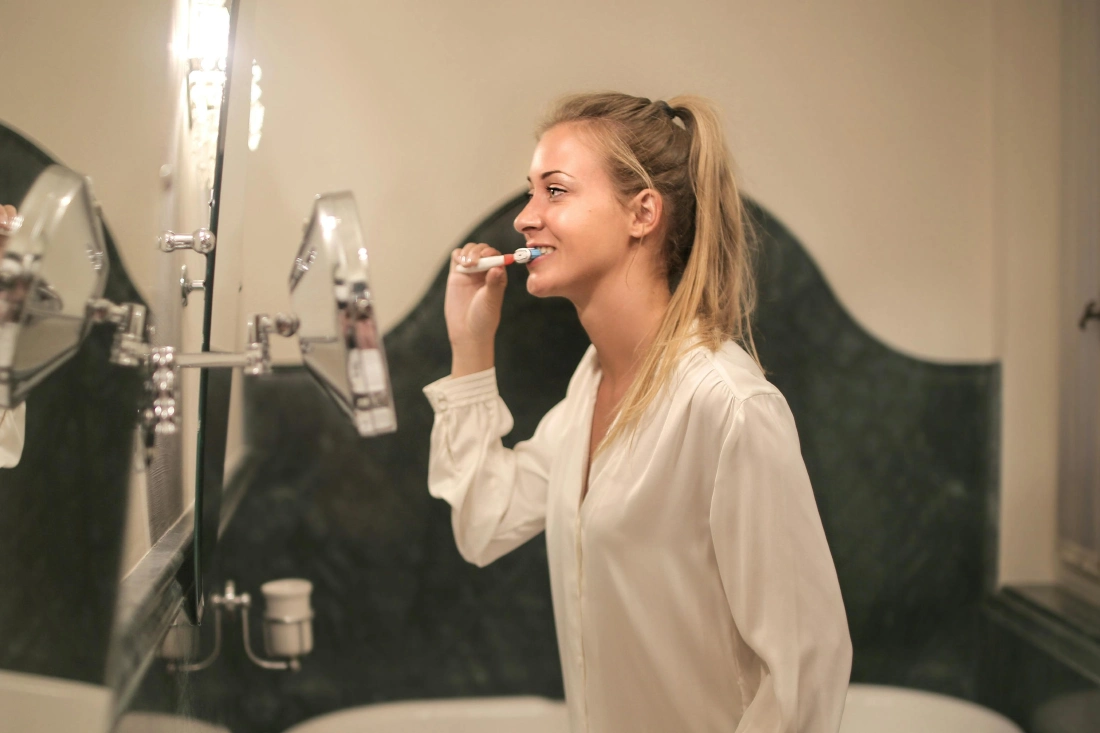 a woman brushing her teeth in the bathroom