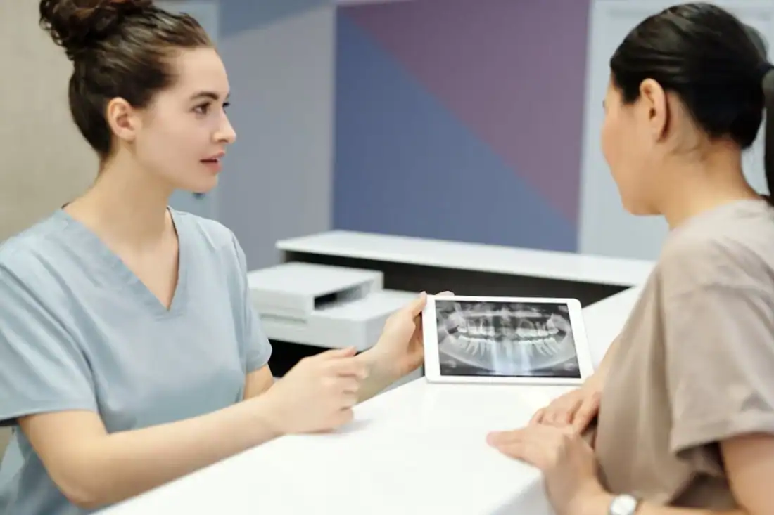 A dentist explains X-ray results to a patient