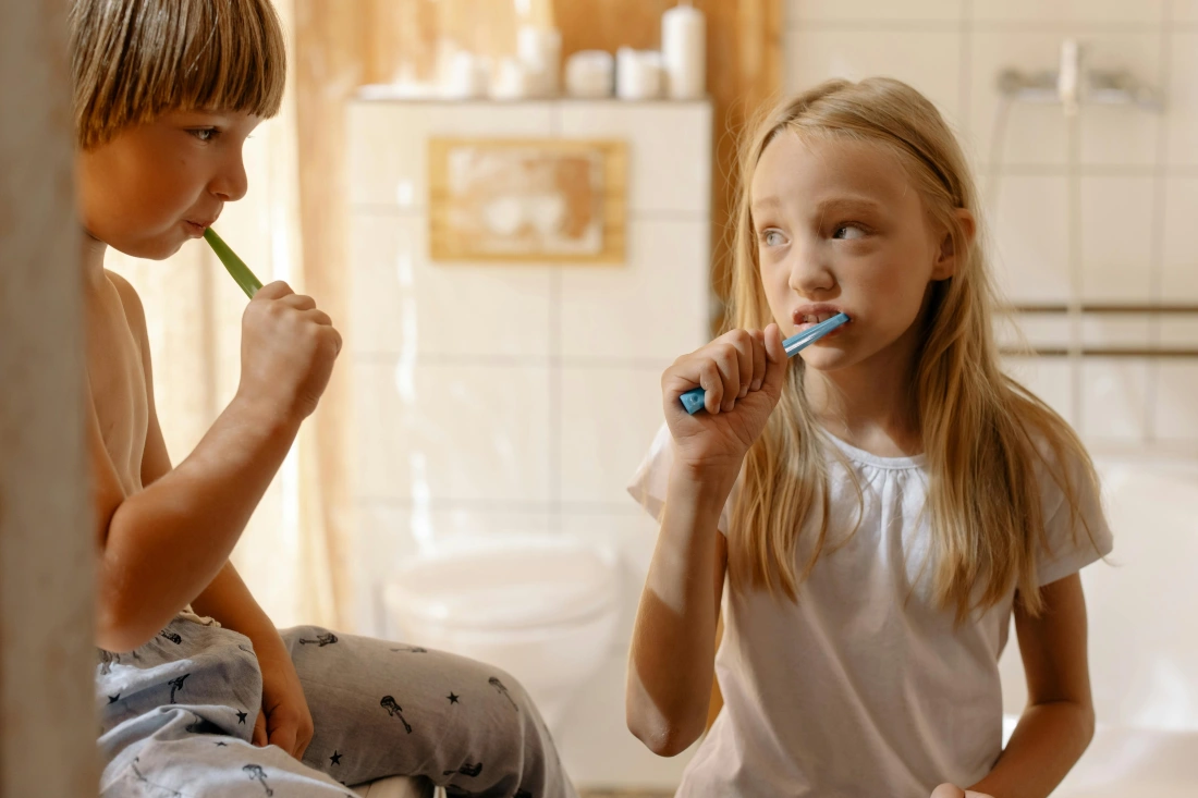 A boy and girl brushing their teeth.