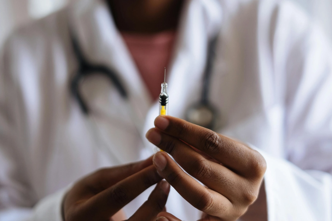 A doctor holding a syringe.