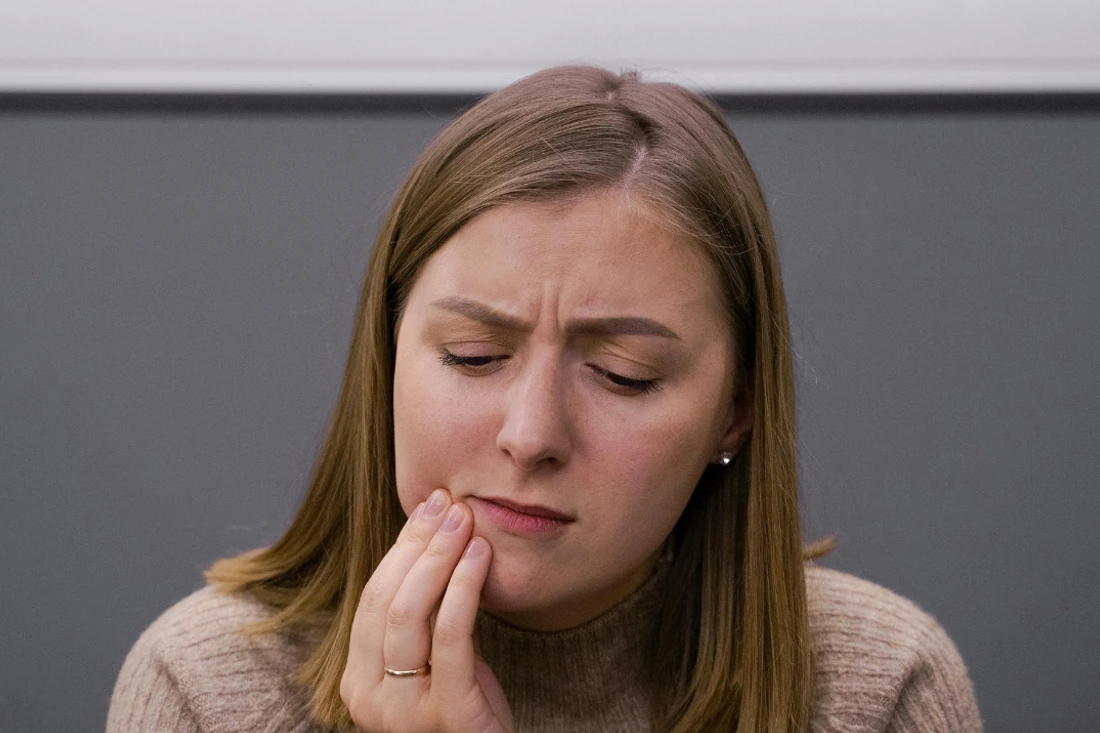 A woman experiencing tooth sensitivity after veneers application.