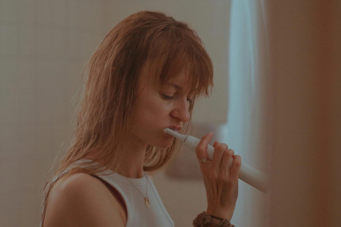 A girl brushing her teeth.