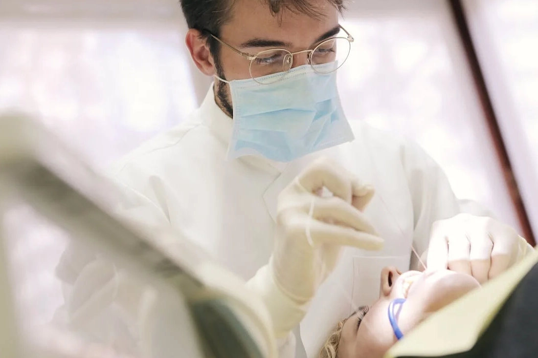 Close-up of a dentist in a face mask working on a patient's dental care.