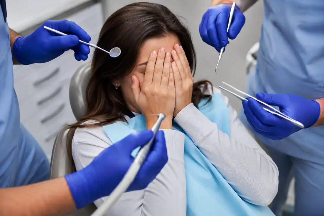scared woman with hands over face at dentist